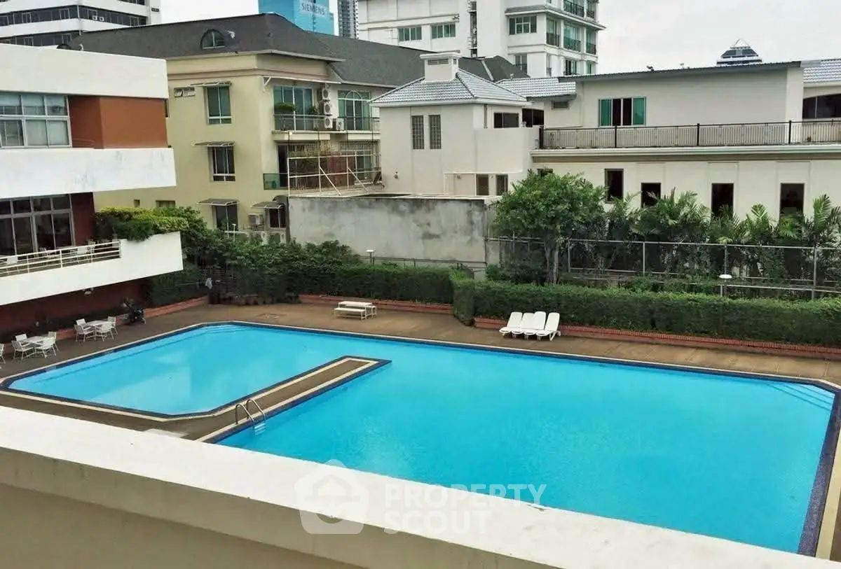 Luxurious residential complex with a pristine swimming pool and lush greenery, perfect for relaxation and leisure.