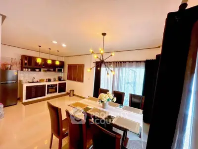 Spacious dining area with modern lighting and open kitchen layout