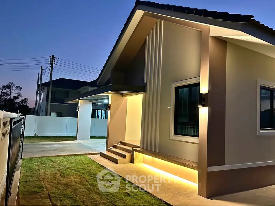 Modern single-story house with stylish exterior lighting and manicured lawn at dusk.