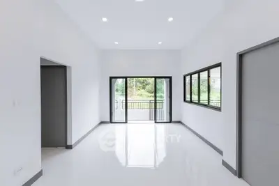 Spacious modern living room with large windows and balcony view