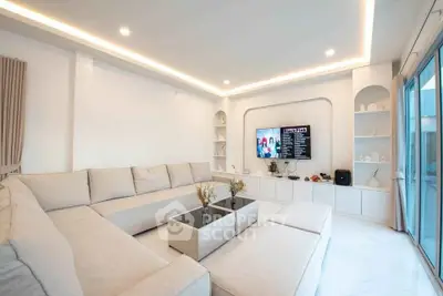 Luxurious modern living room with elegant white decor and spacious seating area.