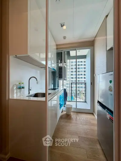 Modern kitchen with sleek design and balcony view in high-rise apartment