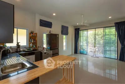 Spacious kitchen with open layout and large windows overlooking greenery.