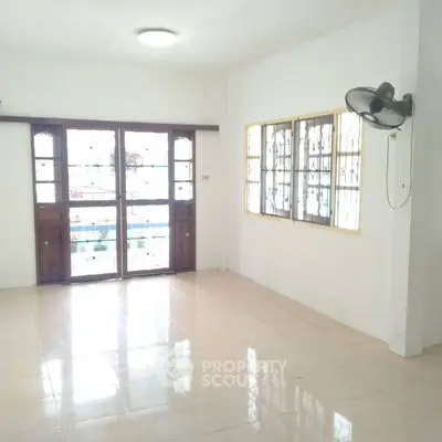 Spacious empty room with large windows and tiled floor, perfect for customization.