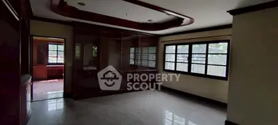 Spacious living room with large windows and elegant wooden ceiling design.