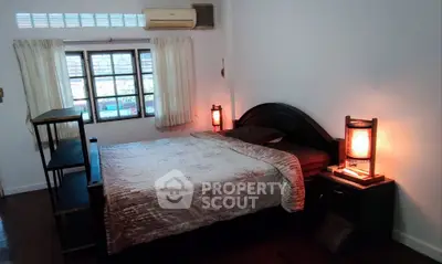 Cozy bedroom with elegant lighting and wooden furniture, perfect for relaxation.