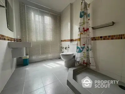 Spacious bathroom with modern fixtures and colorful shower curtain