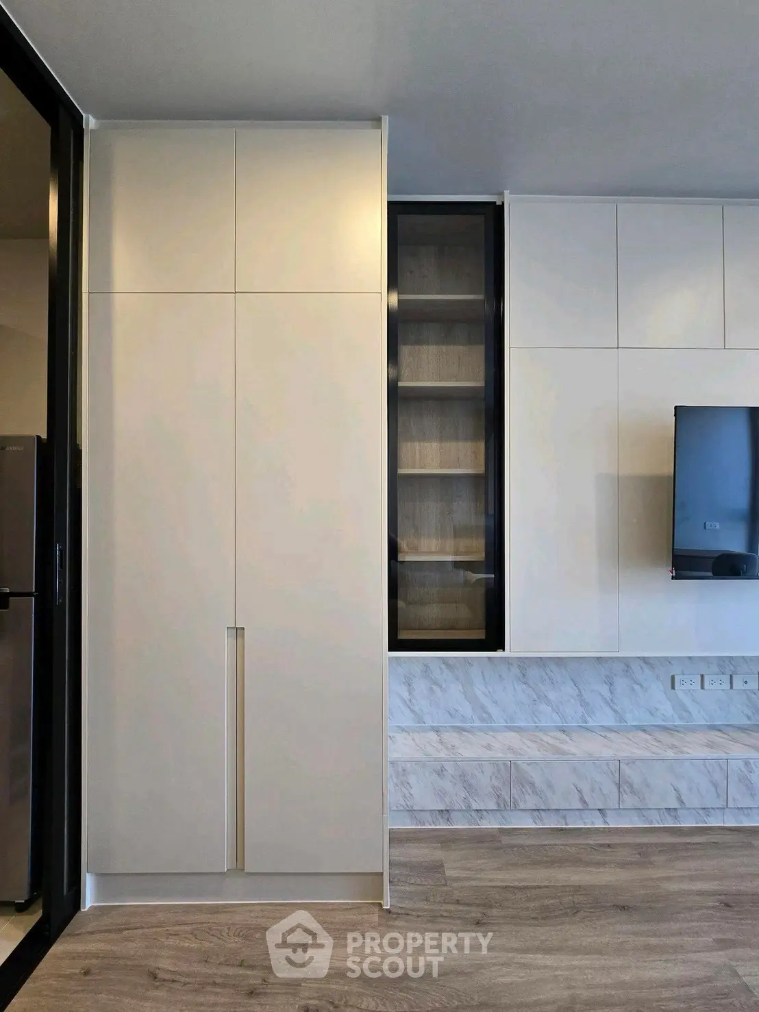Modern minimalist living room with sleek cabinetry and mounted TV