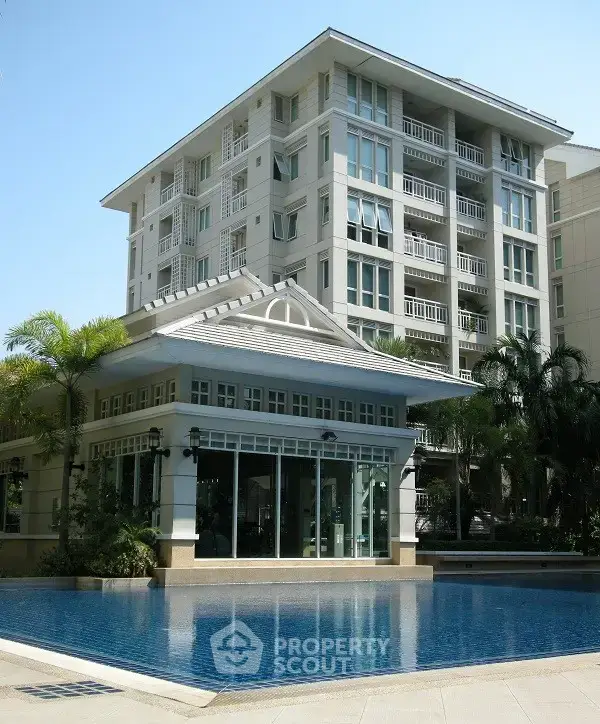 Luxurious residential building with pool and lush greenery, perfect for modern living.
