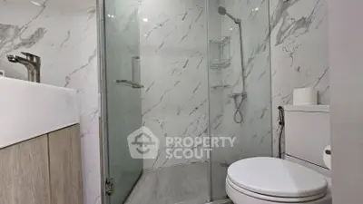 Modern bathroom with glass shower and marble tiles