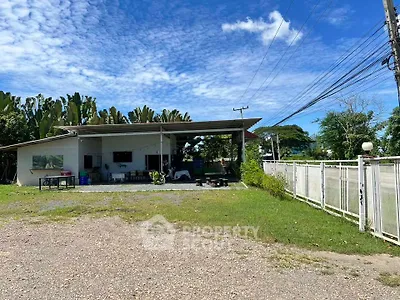 Charming single-story home with lush greenery and spacious outdoor area.