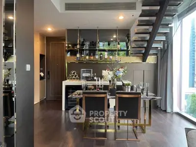 Luxurious modern dining area with elegant decor and open staircase in a high-end apartment.