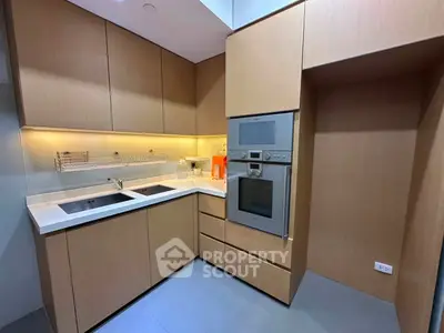 Modern kitchen with sleek cabinetry and built-in appliances in a compact layout.