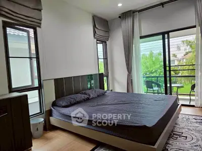 Spacious bedroom with large windows and balcony access in modern home