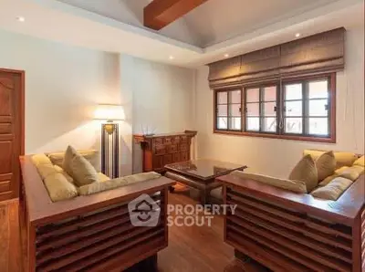 Spacious living room with wooden furniture and large window, perfect for relaxation.