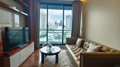 Modern living room with city view, featuring a cozy sofa and large window for natural light.