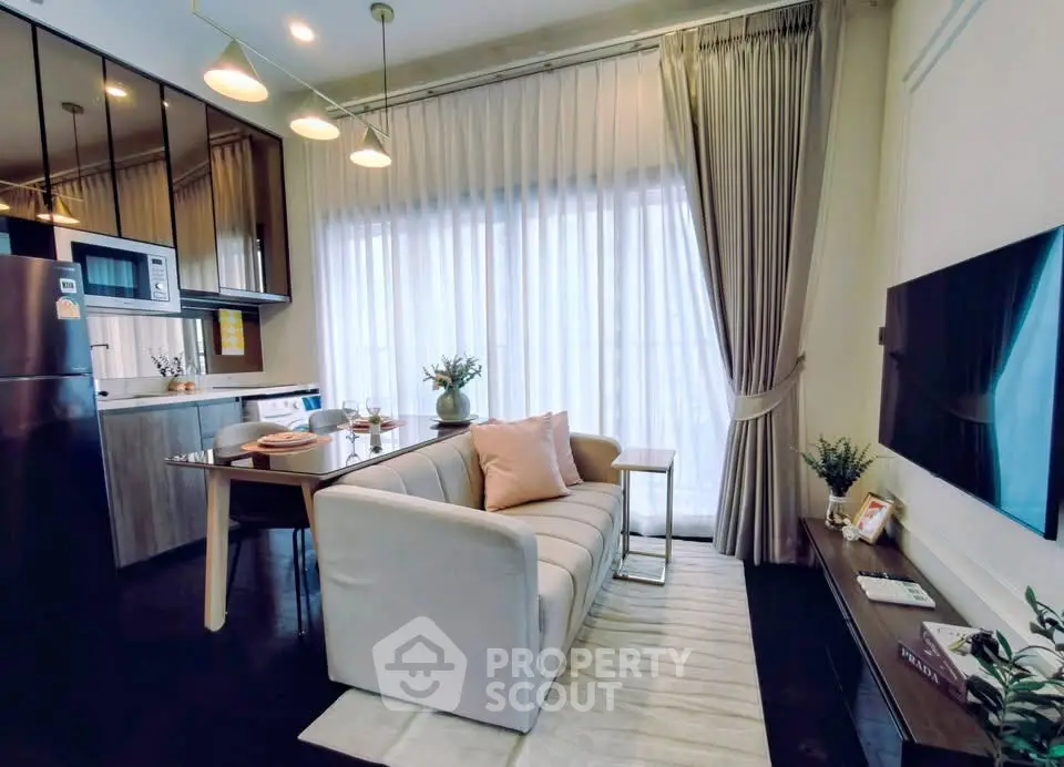 Modern living room with open kitchen, stylish decor, and natural light