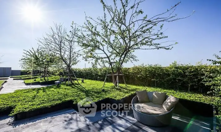 Luxurious rooftop garden with modern seating and lush greenery under a clear blue sky.