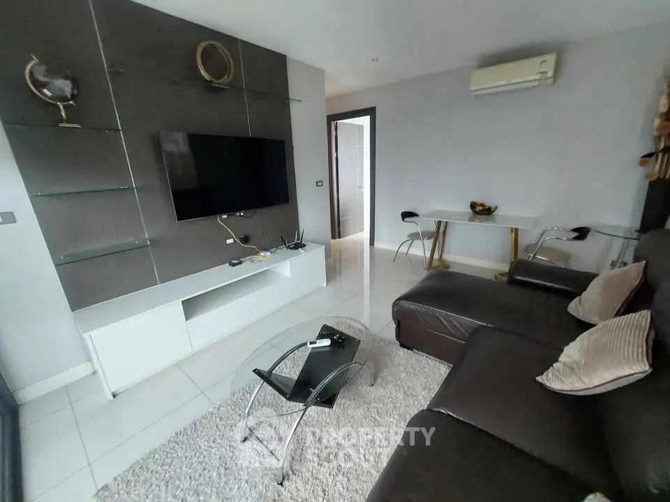 Modern living room with sleek furniture and wall-mounted TV in a stylish apartment.