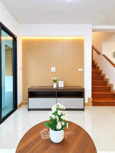 Modern living room with stylish wooden accents and elegant staircase
