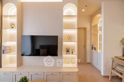 Modern living room with built-in shelves and wall-mounted TV, featuring elegant lighting and stylish decor.
