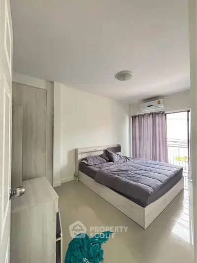 Modern bedroom with sleek design and balcony access, featuring a comfortable bed and stylish decor.