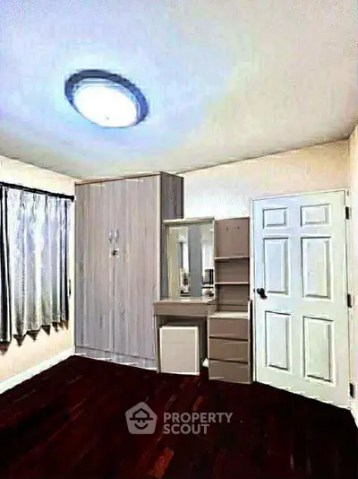 Cozy bedroom with wooden flooring and built-in wardrobe