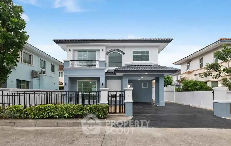 Elegant two-story blue house with spacious driveway and modern design.