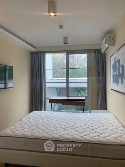 Cozy bedroom with large window and modern decor in a stylish apartment.