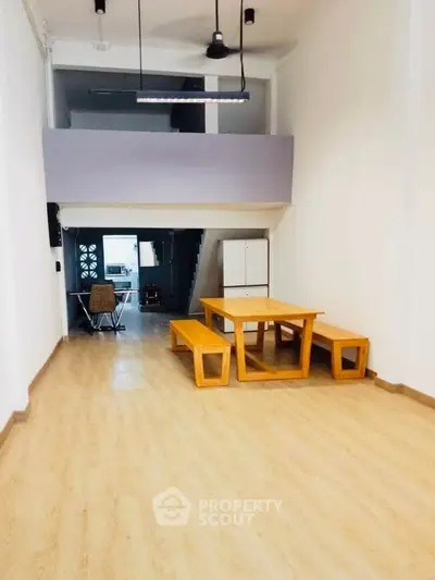 Spacious open-plan living area with modern wooden furniture and mezzanine level.