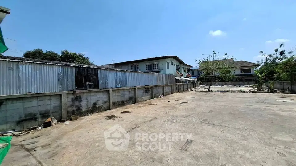 Spacious open lot with potential for development under clear blue skies.