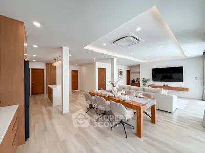 Spacious modern living room with open kitchen and elegant dining area, featuring sleek furniture and ambient lighting.