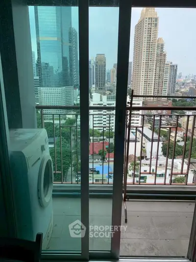 High-rise apartment balcony with city skyline view and washing machine.