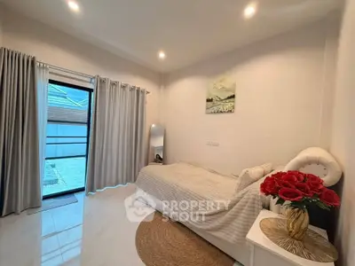 Cozy bedroom with elegant decor and natural light, featuring a single bed and stylish furnishings.