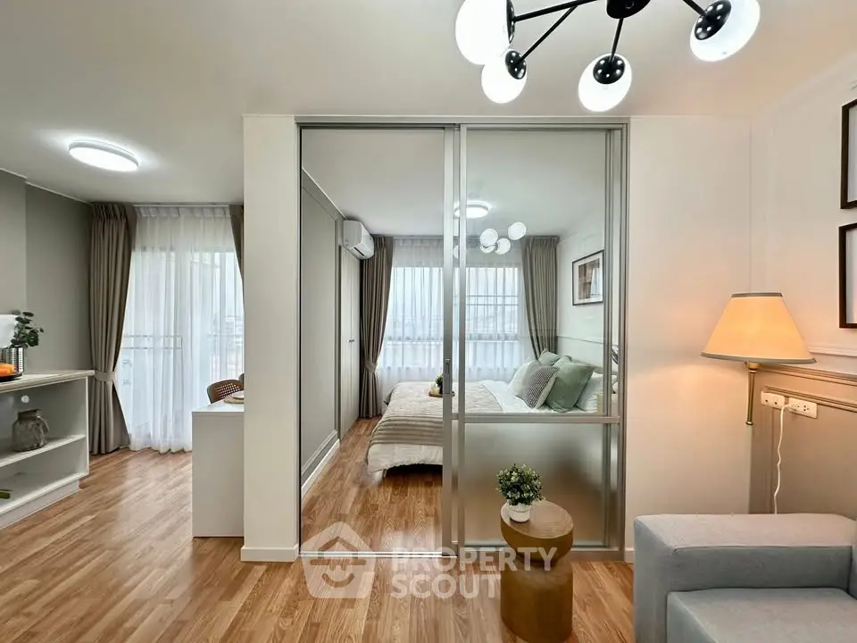 Modern apartment interior with stylish living room and cozy bedroom separated by glass doors.