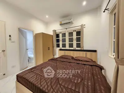 Cozy bedroom with modern furnishings and ensuite bathroom in a stylish apartment.
