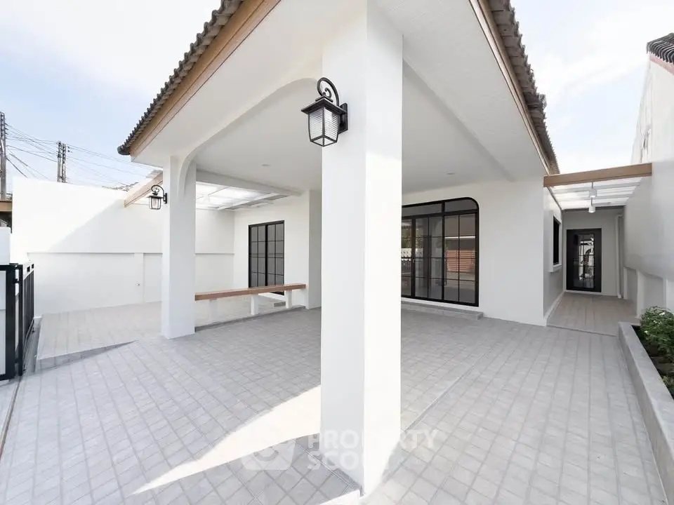 Modern minimalist exterior with spacious tiled patio and elegant lighting fixtures.