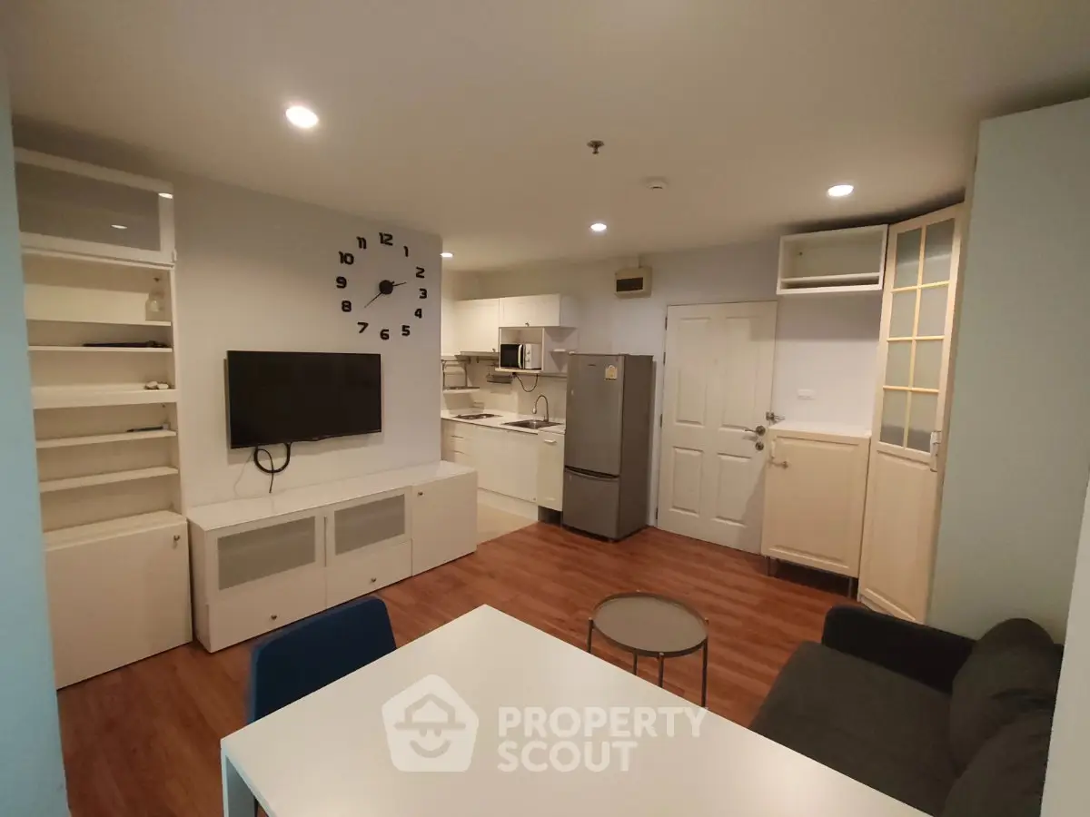 Modern open-plan living room with kitchen, featuring sleek furniture and stylish decor.