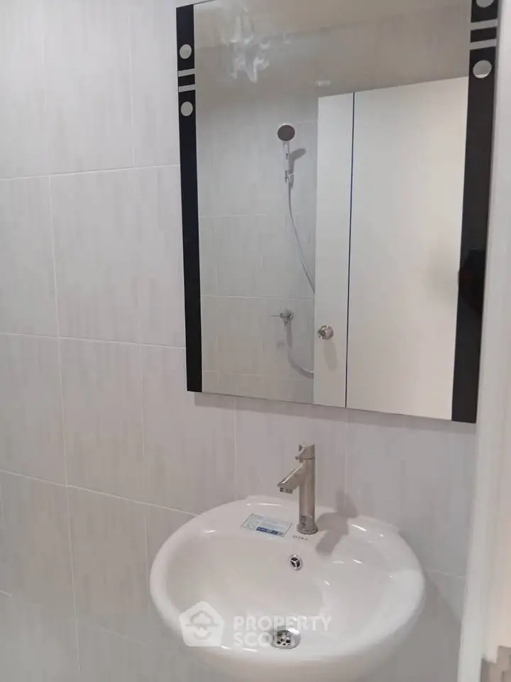 Modern bathroom with sleek sink and mirror in minimalist design.