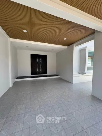 Modern building entrance with sleek design and tiled flooring, showcasing contemporary architecture.