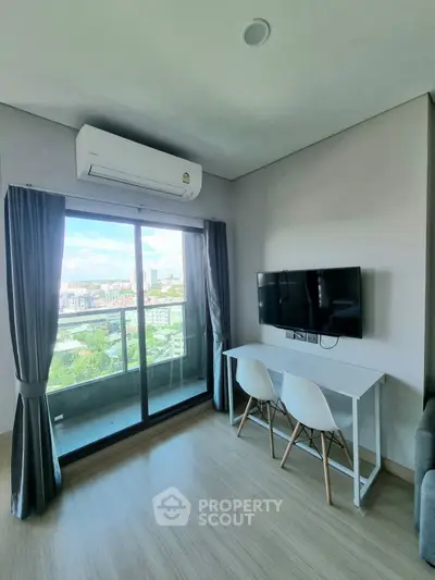 Modern living room with balcony view, air conditioning, and wall-mounted TV in a stylish apartment.