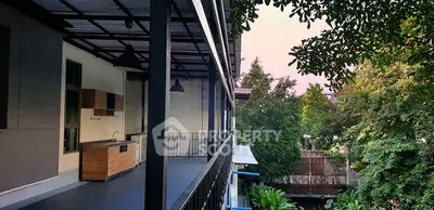 Spacious balcony with outdoor kitchen overlooking lush greenery