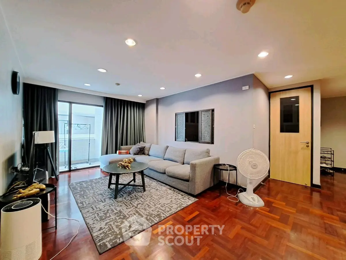 Spacious living room with modern decor and large windows in a stylish apartment.
