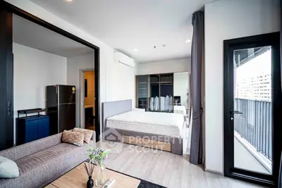 Modern studio apartment with balcony, featuring sleek design and ample natural light, perfect for urban living.