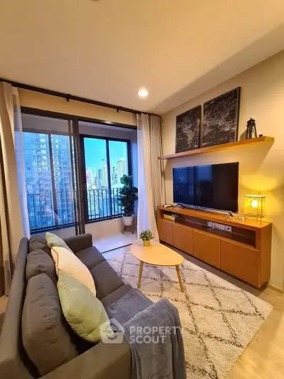Modern living room with city view, cozy sofa, and stylish decor.