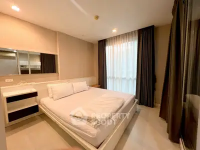 Modern bedroom with large window and elegant curtains in a stylish apartment.