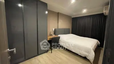 Modern bedroom with sleek wardrobe and cozy workspace