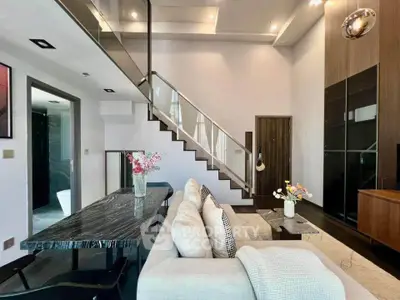 Modern living room with stylish staircase and elegant decor in a luxury apartment.