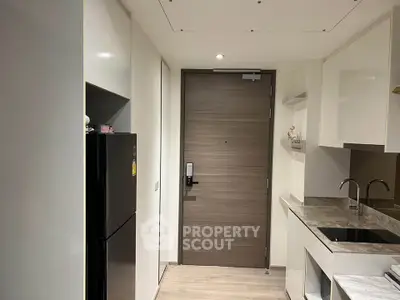 Modern kitchen with sleek cabinetry and stainless steel appliances in a contemporary apartment.