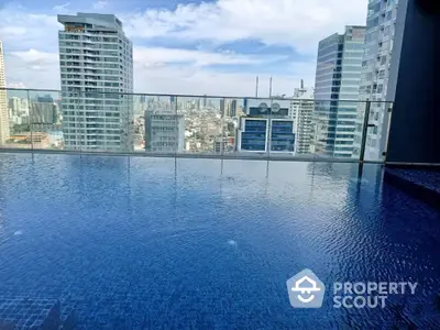 Stunning rooftop pool with panoramic city skyline views in modern high-rise building.